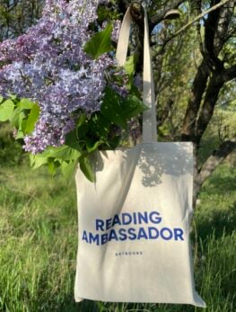 A bag hanging from a tree with purple flowers